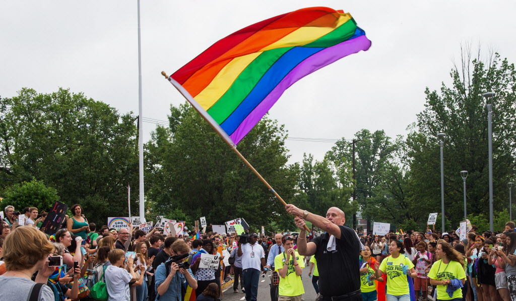 Principal Pete Cahall, waves a rainbow flag, symbolizing gay pride, at a rally of about 1000 Woodrow Wilson High School students and gay supporters June 9, 2014 at Woodrow Wilson High School in Washington, DC. The rally was held to counter a planned protest by Westboro Baptist Church, the Kansas-based organization known for anti-gay picketing at funerals. AFP PHOTO/Paul J. RichardsPAUL J. RICHARDS/AFP/Getty Images